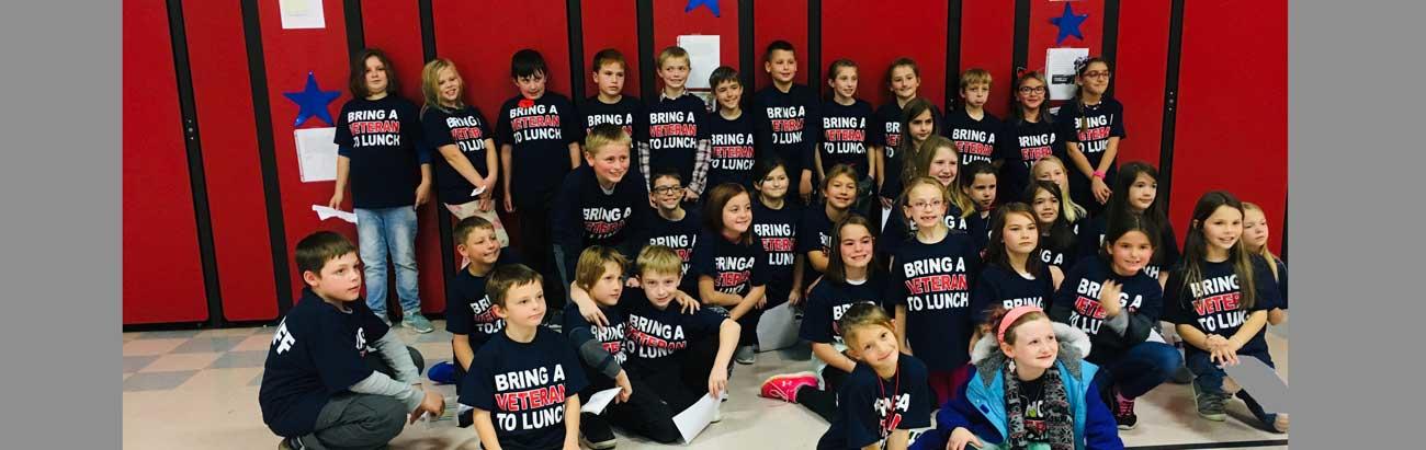 Photo of group of students involved with 'Bring a Veteran to Lunch'. They are all wearing T-Shirts with 'Bring a Veteran to Lunch' printed on them.